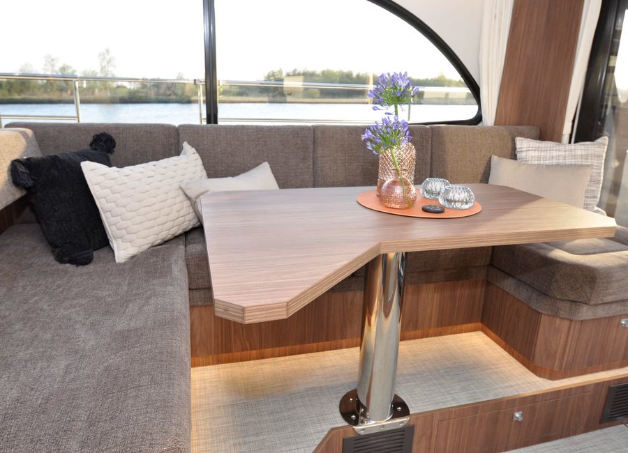 Ecksofa und Tisch im Salon der luxuriösen Motoryacht Amazon NoblesseCruiser 42